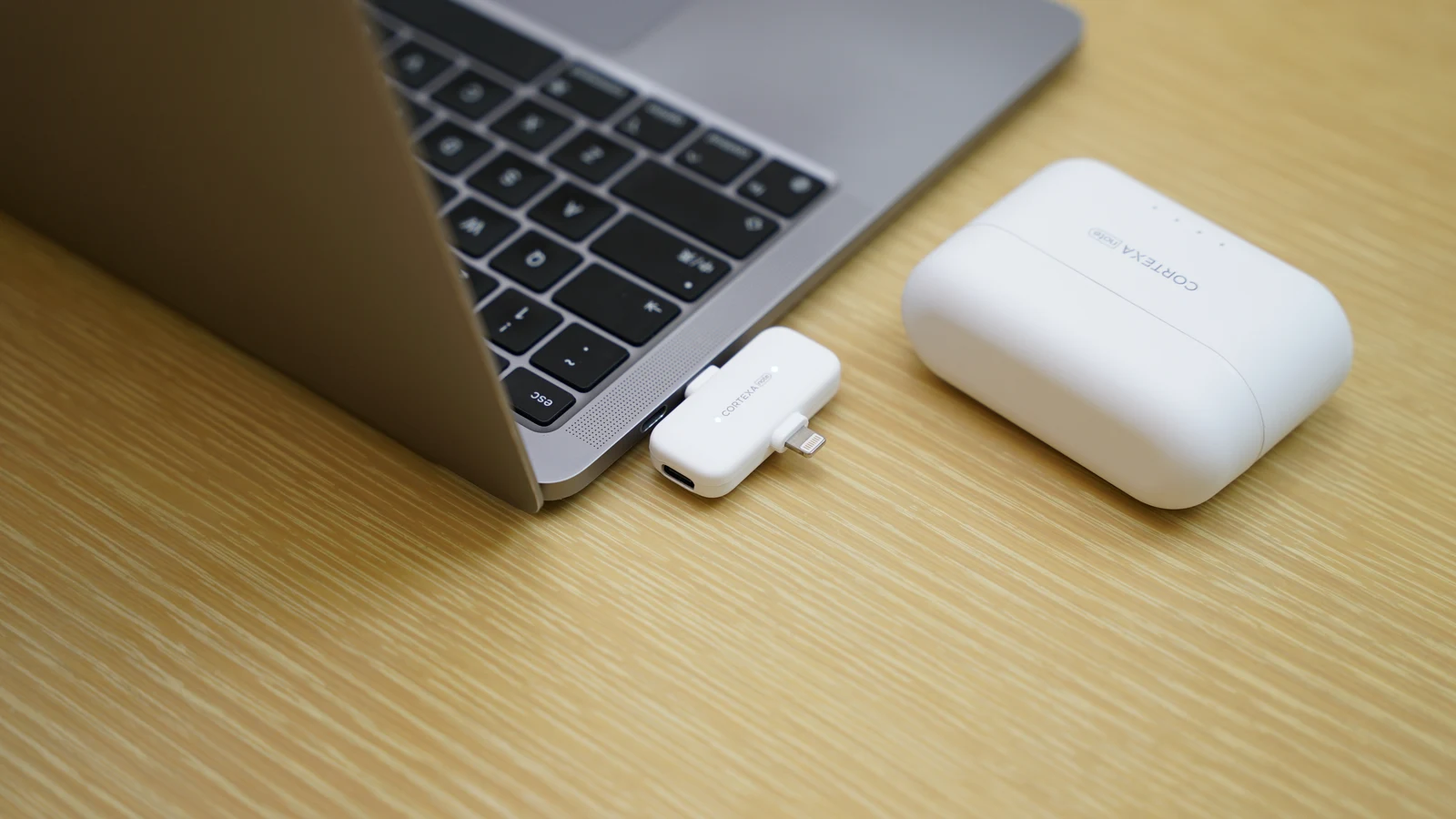 R1 receiver connected to a laptop beside its charging case