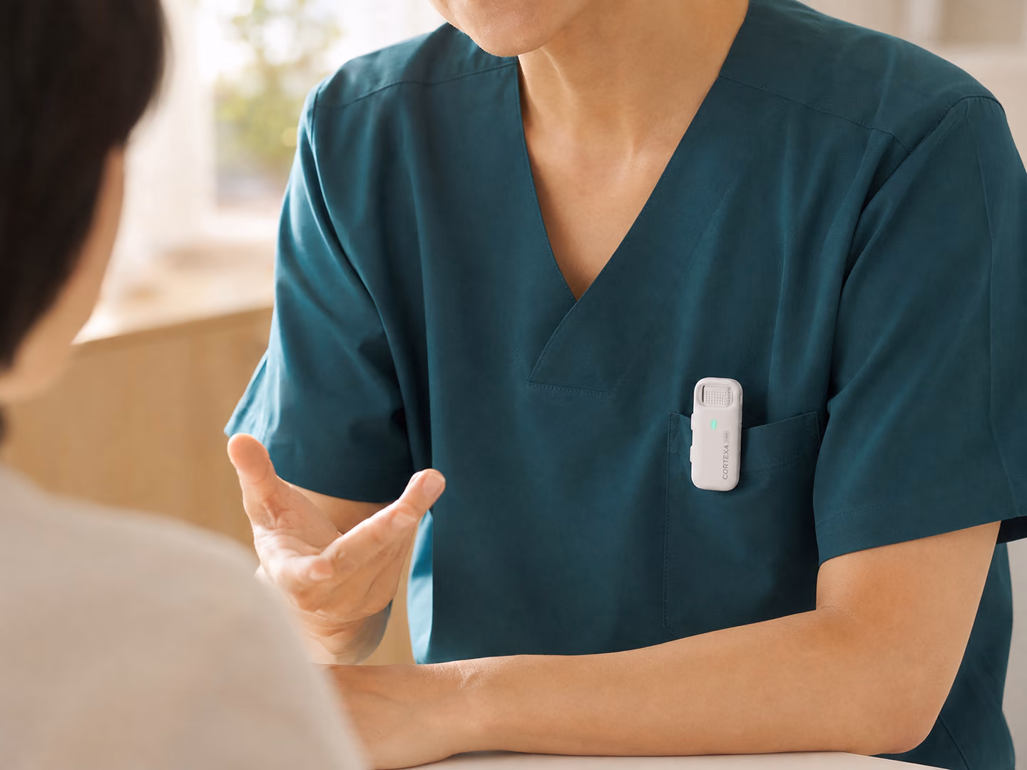 A clinician wearing the R1 microphone during a patient conversation